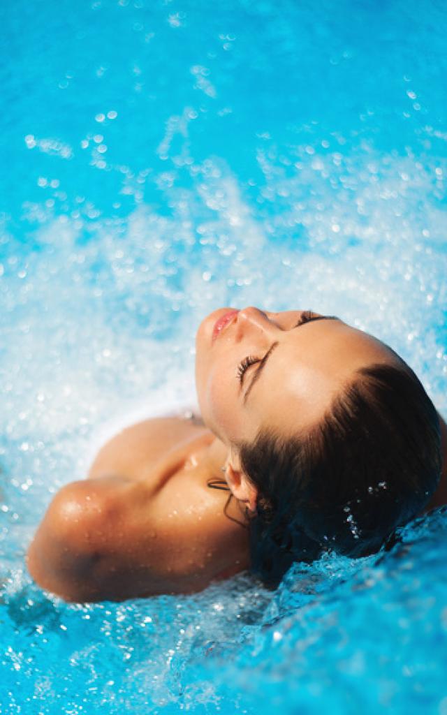 Mooie vrouw in een zwembad onder water stroom