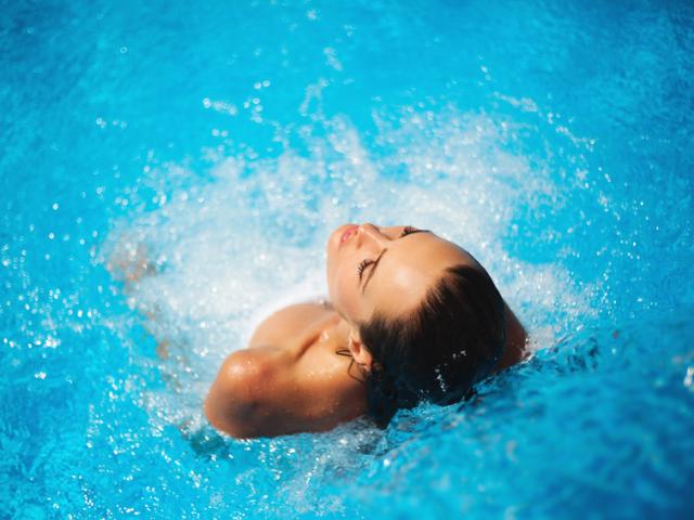 Mooie vrouw in een zwembad onder water stroom