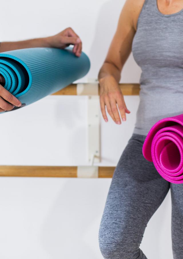 deux personnes en tenue de sport tenant leur tapis