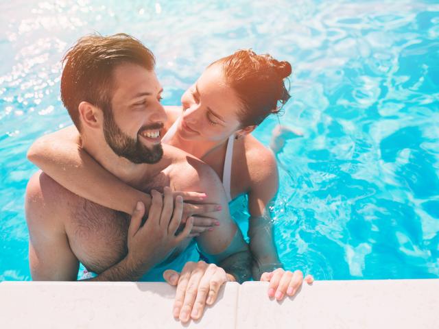 Jeune couple dans la piscine sous le soleil