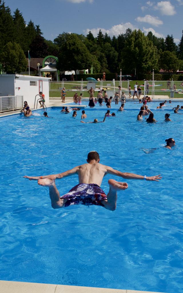 Jeune homme plongeant dans la piscine de plein air des Lacs de la Folie à Contrexéville