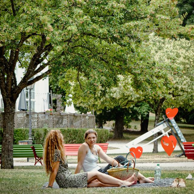 Deux femmes assises dans l'herbe du parc thermal de Contrexéville
